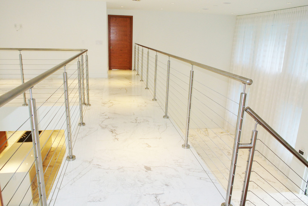 Idée de décoration pour un grand couloir design avec un mur blanc et un sol en marbre.