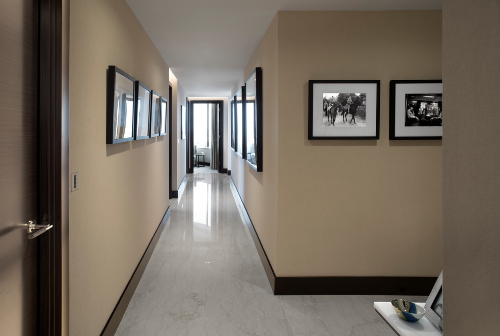 На фото: большой коридор в современном стиле с бежевыми стенами, мраморным полом и белым полом с