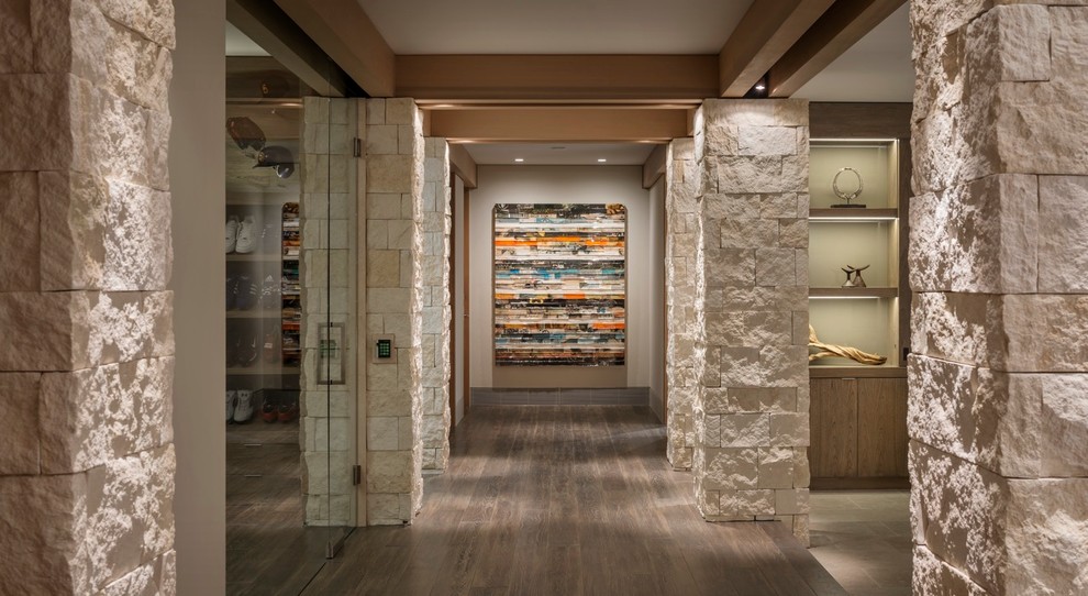 Cette image montre un couloir design avec un mur beige, parquet foncé et un sol marron.