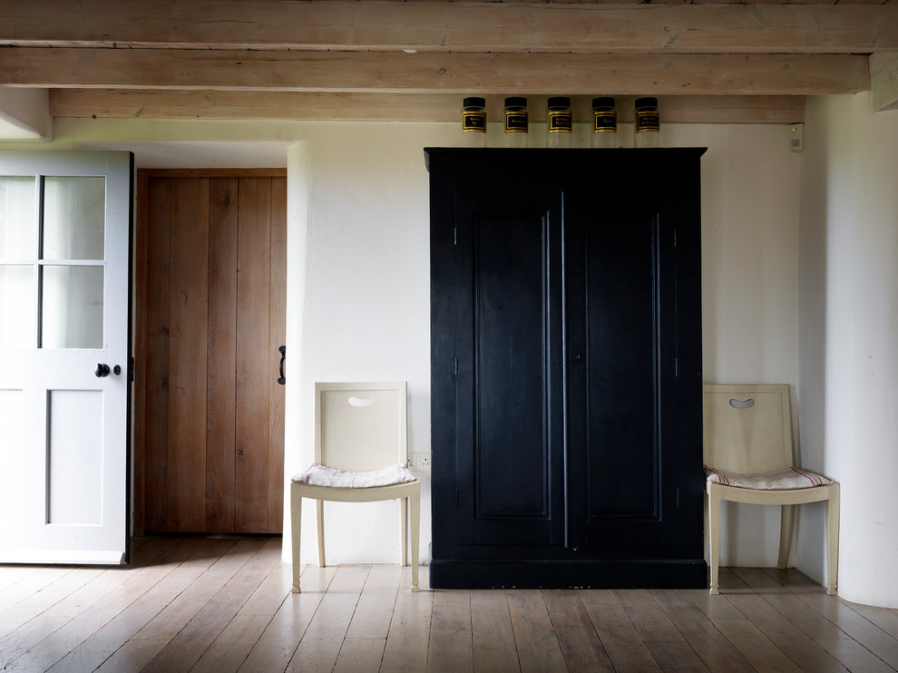 Foto de recibidores y pasillos clásicos de tamaño medio con paredes blancas, suelo de madera en tonos medios y suelo marrón