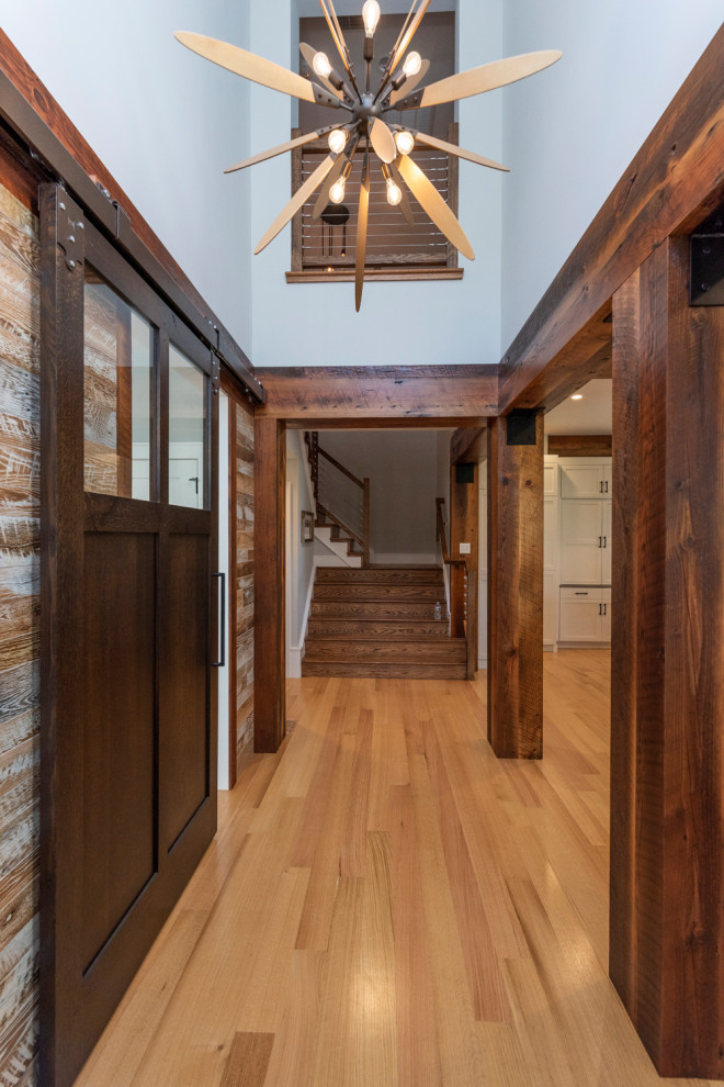 Источник вдохновения для домашнего уюта: большой коридор в стиле кантри с синими стенами, черным полом и деревянными стенами