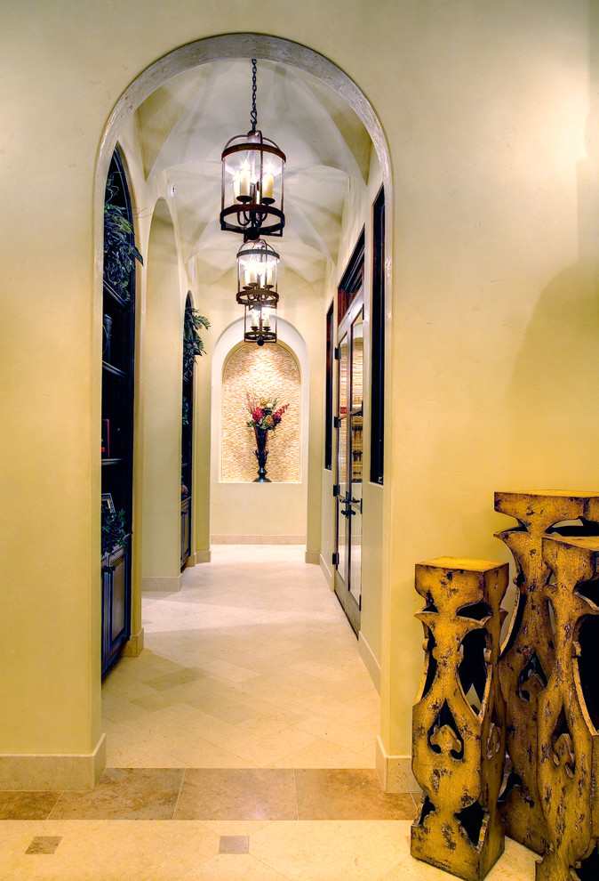 Example of a tuscan beige floor hallway design in Austin with beige walls