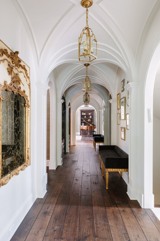 Esempio di un ampio ingresso o corridoio chic con pareti bianche, pavimento in legno massello medio e pavimento marrone