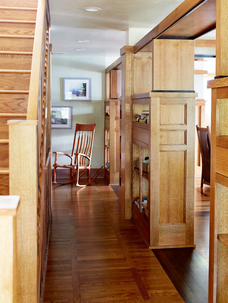 Idée de décoration pour un couloir craftsman de taille moyenne avec un mur vert et un sol en bois brun.