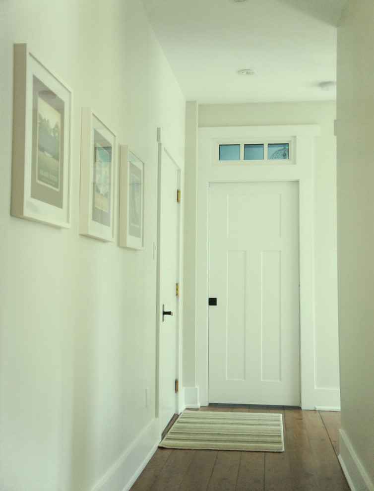 Inspiration for a mid-sized timeless medium tone wood floor hallway remodel in Ottawa with white walls