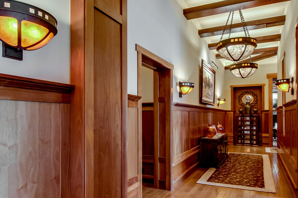 Hallway - large craftsman medium tone wood floor hallway idea in San Diego with beige walls