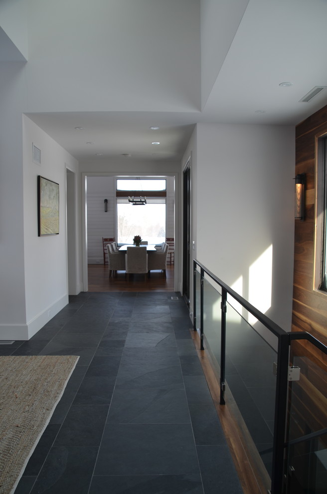 На фото: коридор в современном стиле с белыми стенами, полом из сланца и серым полом с