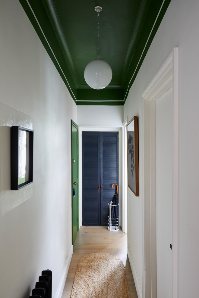 Esempio di un piccolo ingresso o corridoio design con pareti bianche, parquet chiaro e pavimento beige