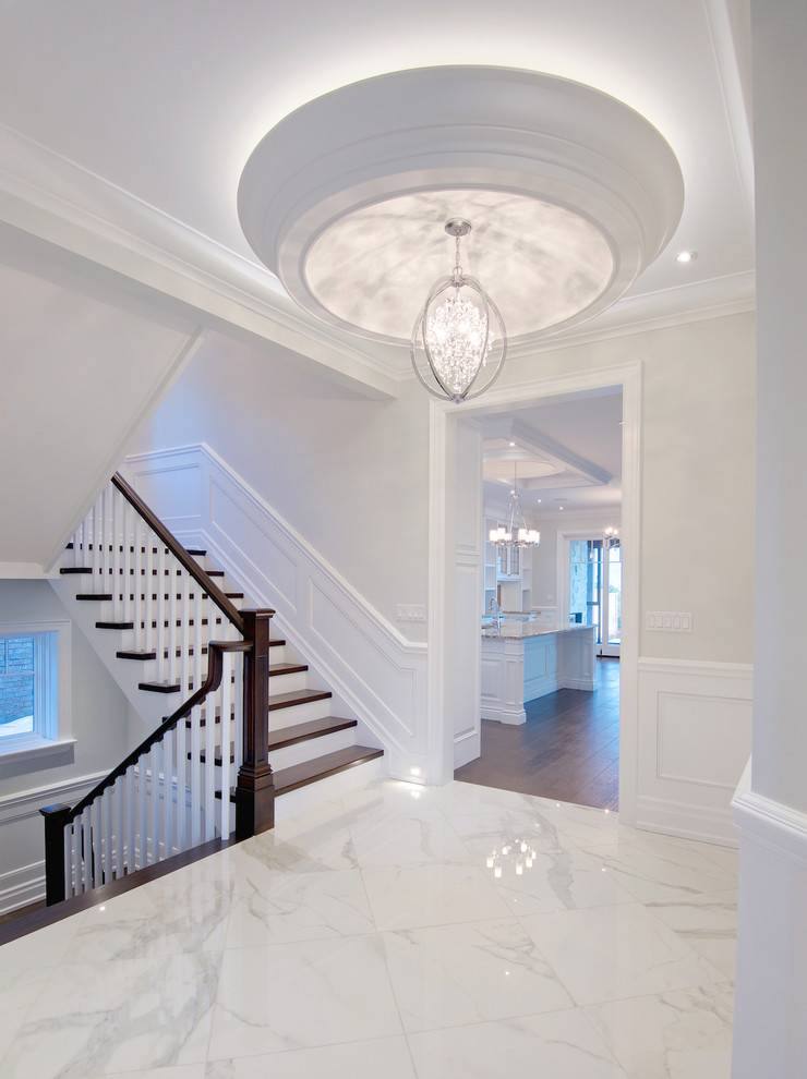 Cette image montre un grand couloir design avec un mur blanc et un sol en marbre.
