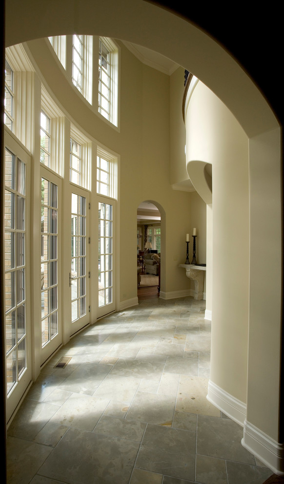 Idée de décoration pour un très grand couloir tradition avec un mur beige et un sol en calcaire.
