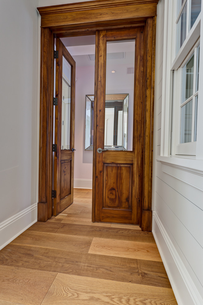 Réalisation d'un couloir craftsman de taille moyenne avec un sol en bois brun, un mur gris et un sol marron.