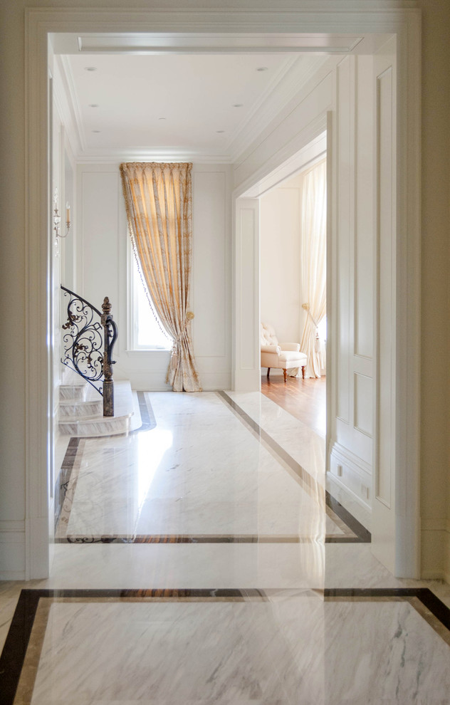На фото: большой коридор в викторианском стиле с белыми стенами, мраморным полом и серым полом
