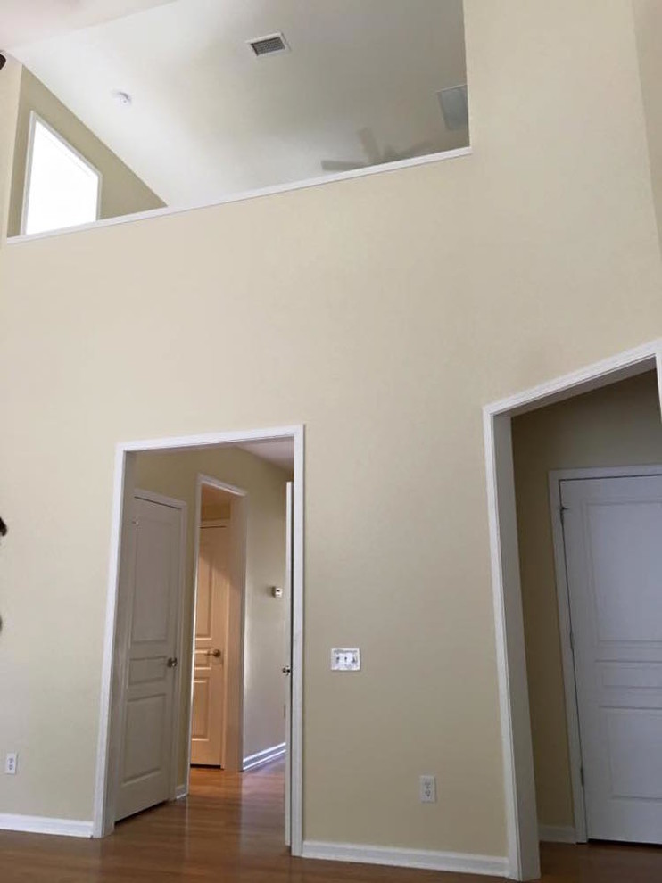 Cette photo montre un couloir chic de taille moyenne avec un mur beige, parquet clair et un sol beige.