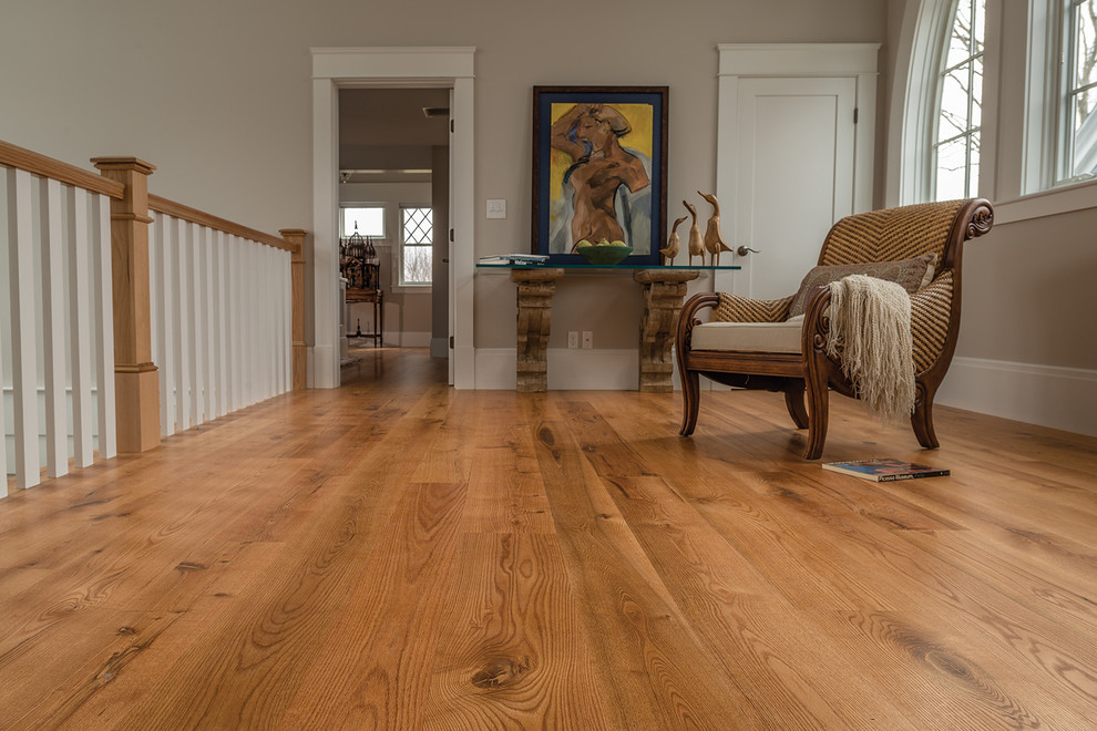 Example of a large classic light wood floor hallway design in Portland Maine with beige walls