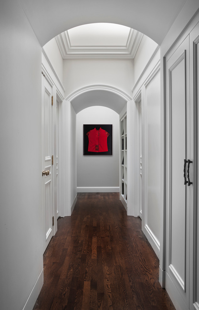 Inspiration for a mid-sized timeless dark wood floor and brown floor hallway remodel in Detroit with white walls