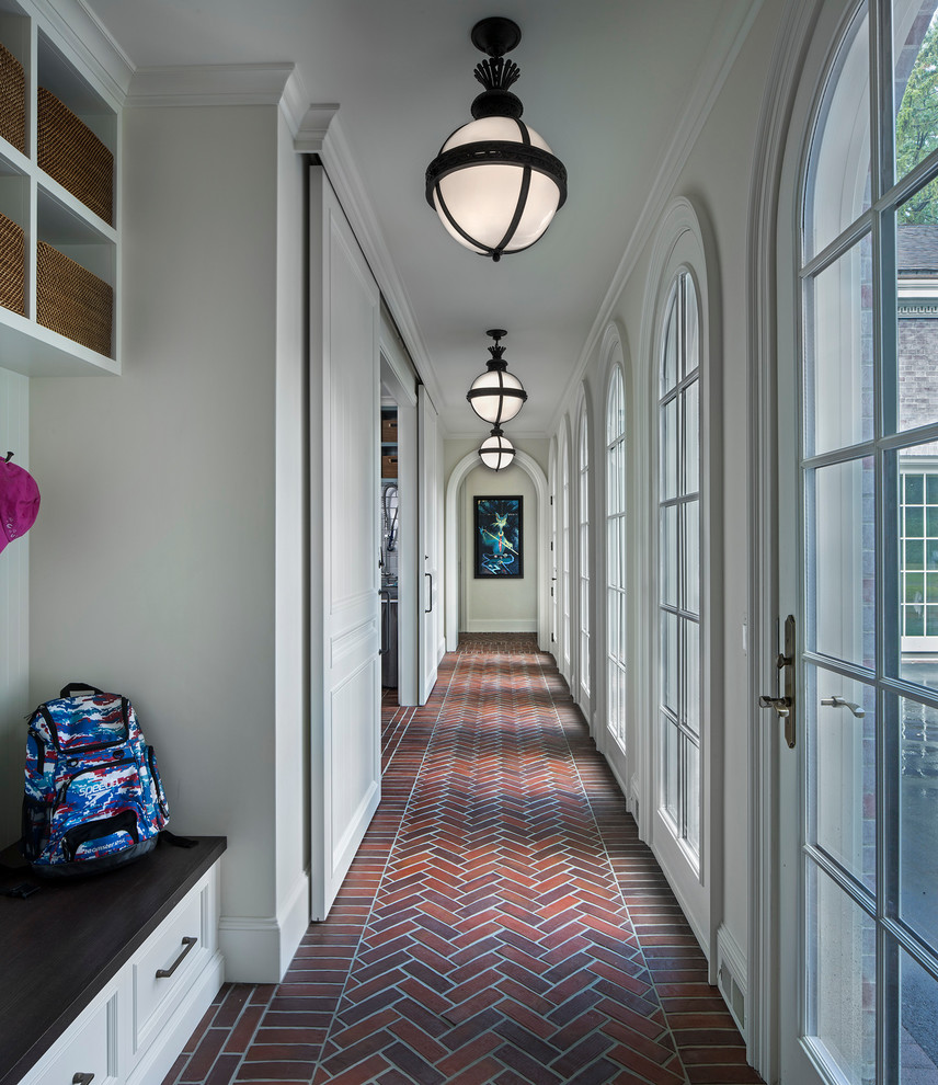 Свежая идея для дизайна: большой коридор в классическом стиле с серыми стенами, кирпичным полом и красным полом - отличное фото интерьера