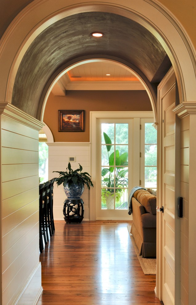Example of a mid-sized beach style medium tone wood floor, brown floor, wood ceiling and wall paneling hallway design in Charleston with brown walls