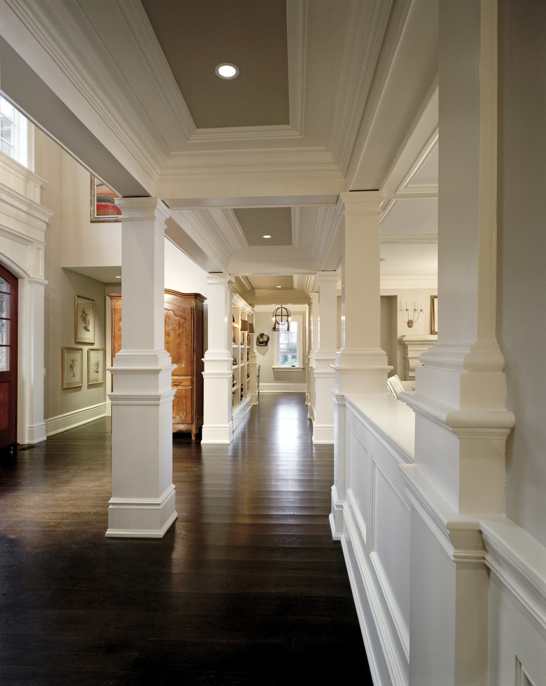 Aménagement d'un couloir classique avec un mur blanc et parquet foncé.