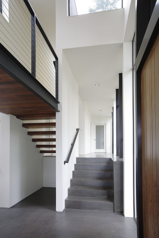 Idee per un ingresso o corridoio minimalista di medie dimensioni con pareti bianche e pavimento in cemento