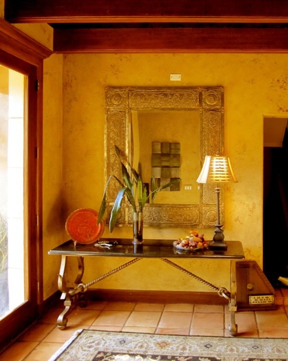 Hallway - mid-sized mediterranean terra-cotta tile and orange floor hallway idea in Tampa with beige walls