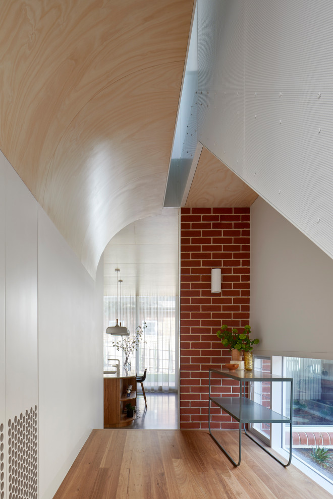 Großer Moderner Flur mit brauner Wandfarbe, braunem Holzboden, braunem Boden und Holzwänden in Melbourne