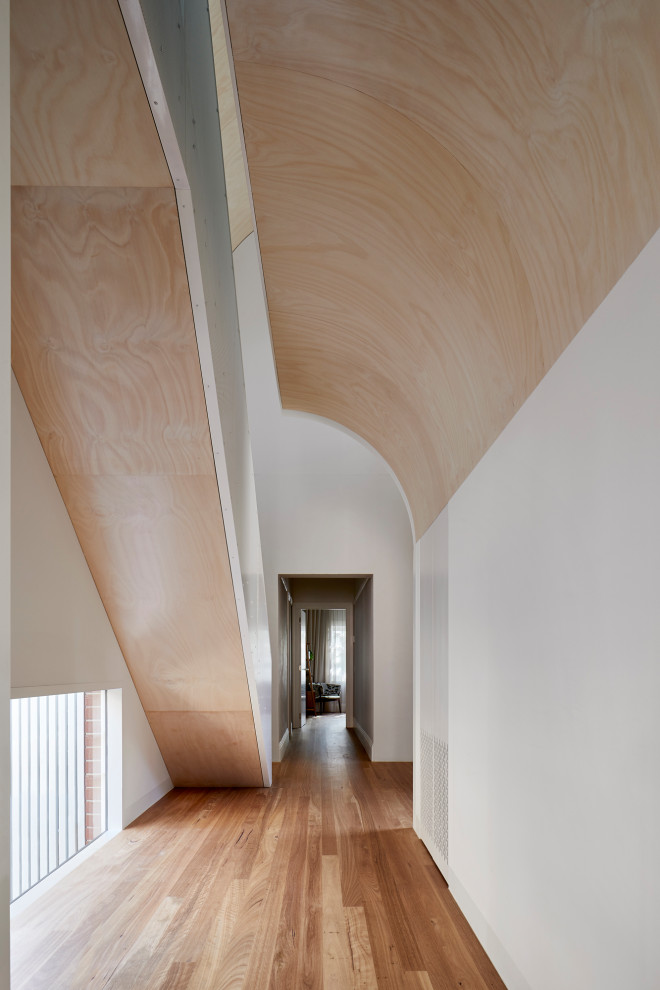 Идея дизайна: большой коридор в современном стиле с коричневыми стенами, паркетным полом среднего тона, коричневым полом и деревянными стенами