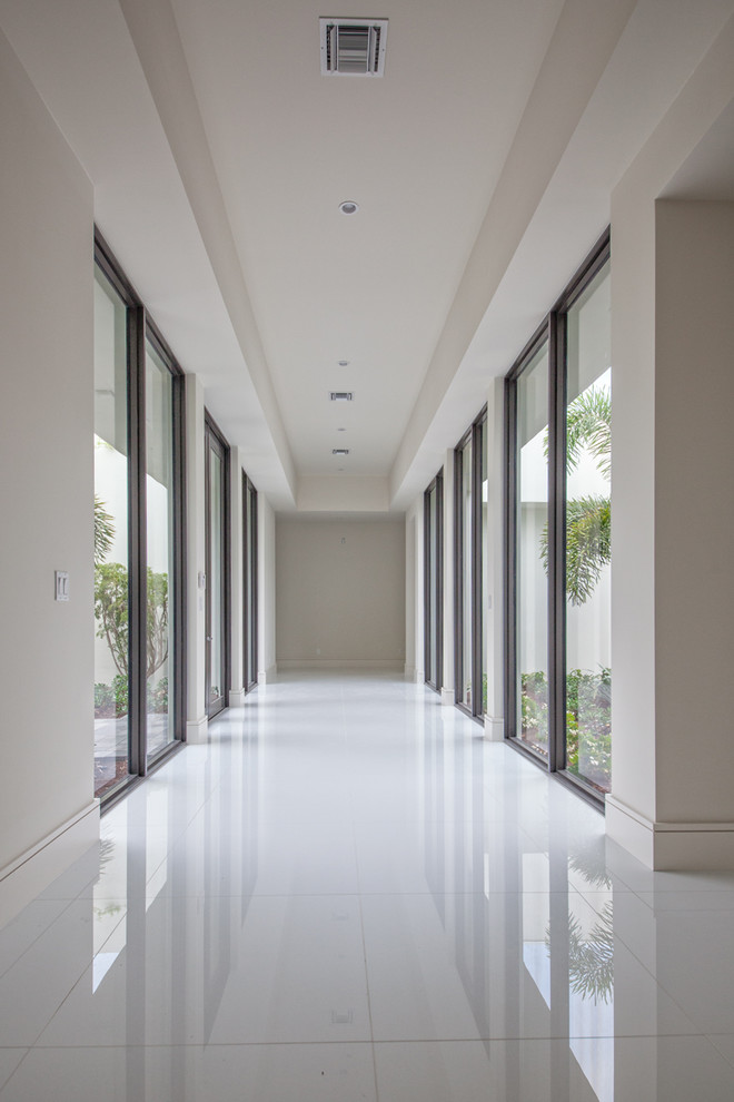 Idée de décoration pour un grand couloir minimaliste avec un mur gris et un sol blanc.