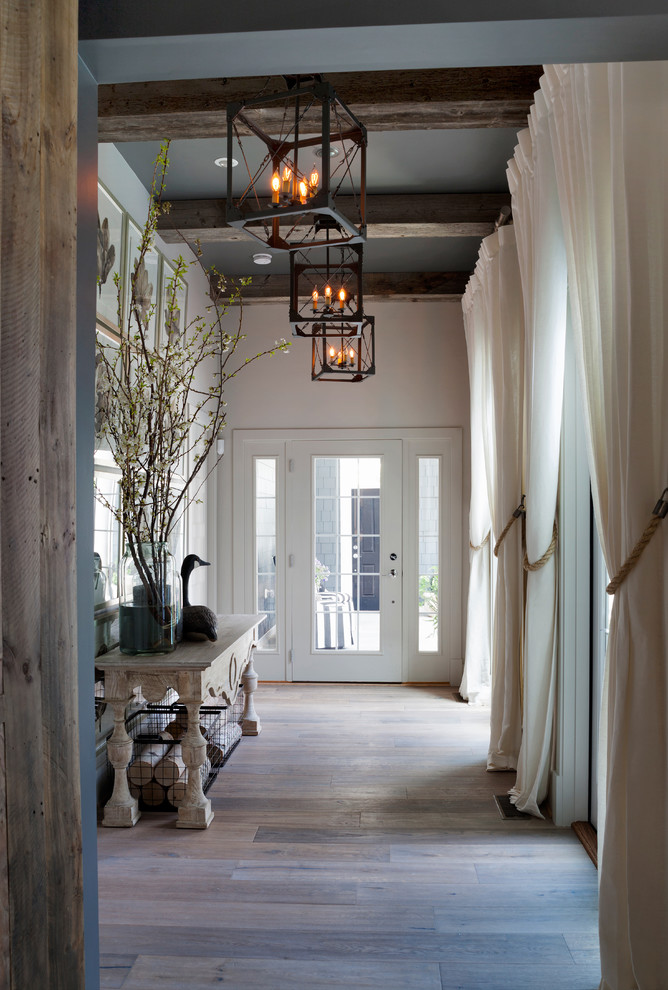 Photo of a large beach style hallway in Charlotte with white walls, light hardwood floors and grey floor.