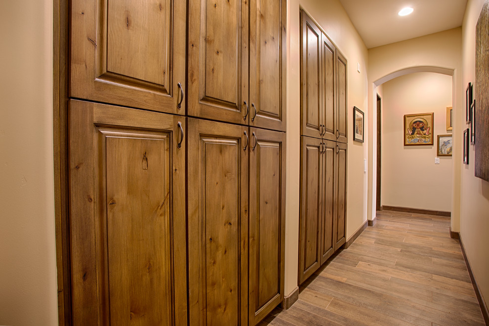 Ejemplo de recibidores y pasillos de estilo americano de tamaño medio con paredes beige y suelo de madera en tonos medios