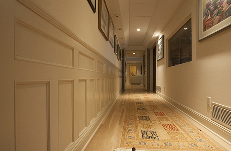 Cette photo montre un grand couloir chic avec un mur beige et moquette.