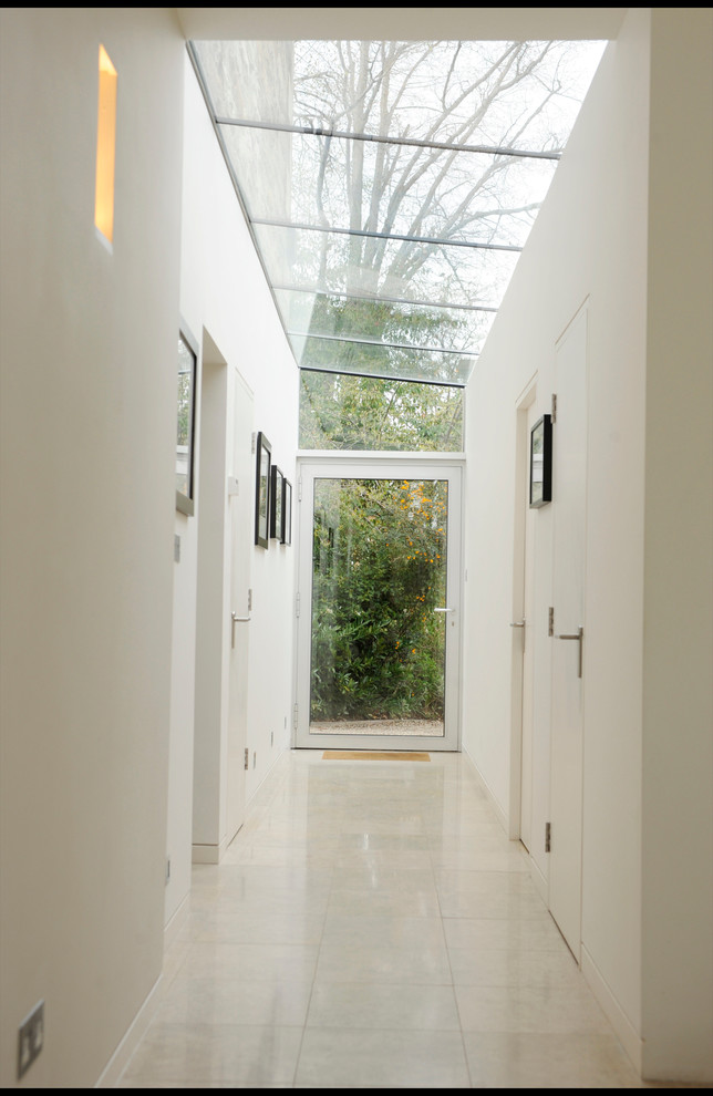 Idee per un ingresso o corridoio minimal di medie dimensioni con pareti bianche e pavimento in gres porcellanato