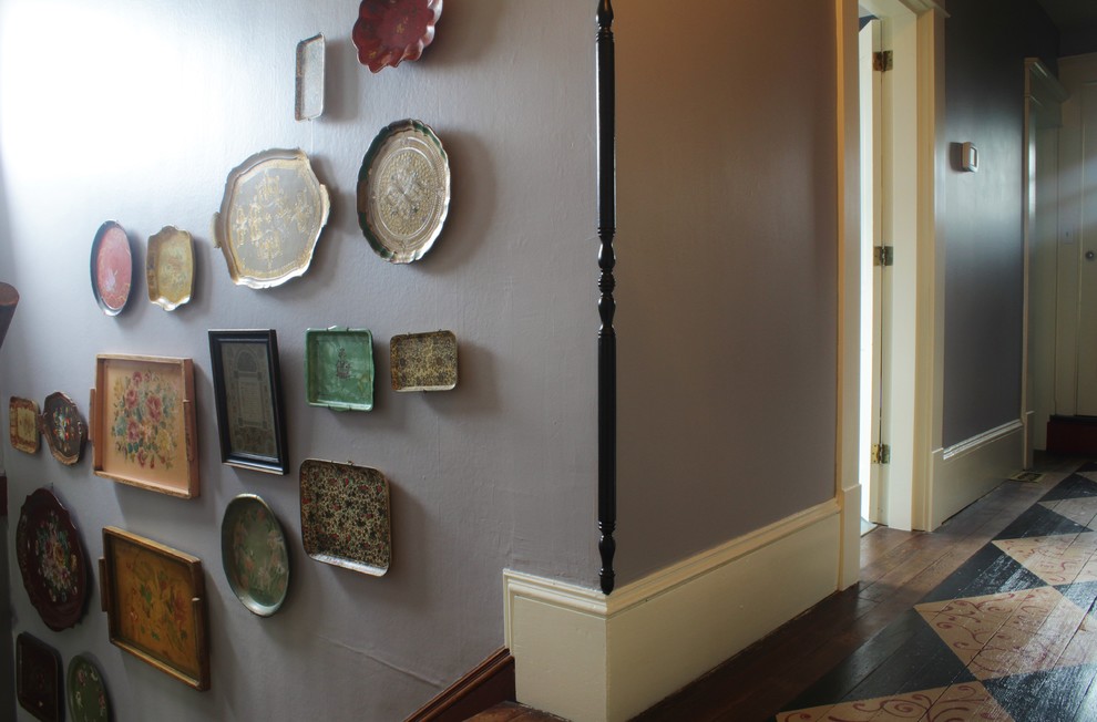 Immagine di un piccolo ingresso o corridoio boho chic con pareti viola e pavimento in legno verniciato