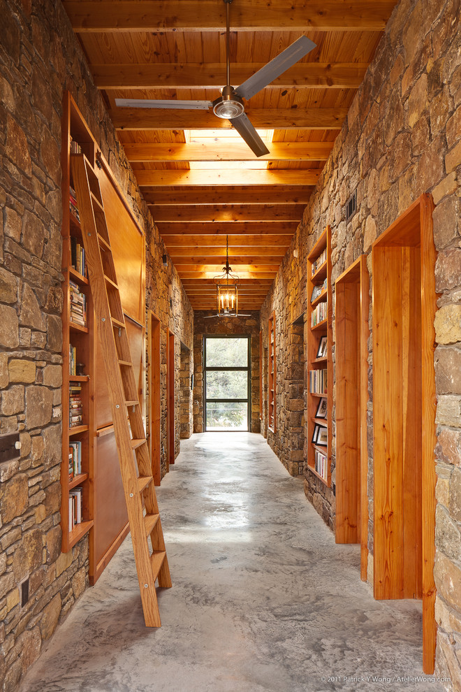 Example of a large eclectic concrete floor hallway design in Austin with beige walls