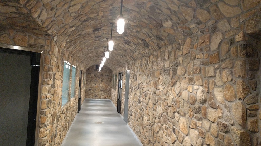 Esempio di un ingresso o corridoio rustico con pareti marroni, pavimento in cemento e pavimento grigio