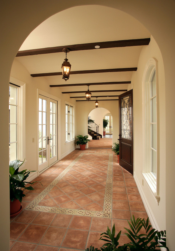 Elegant terra-cotta tile hallway photo in Los Angeles with beige walls
