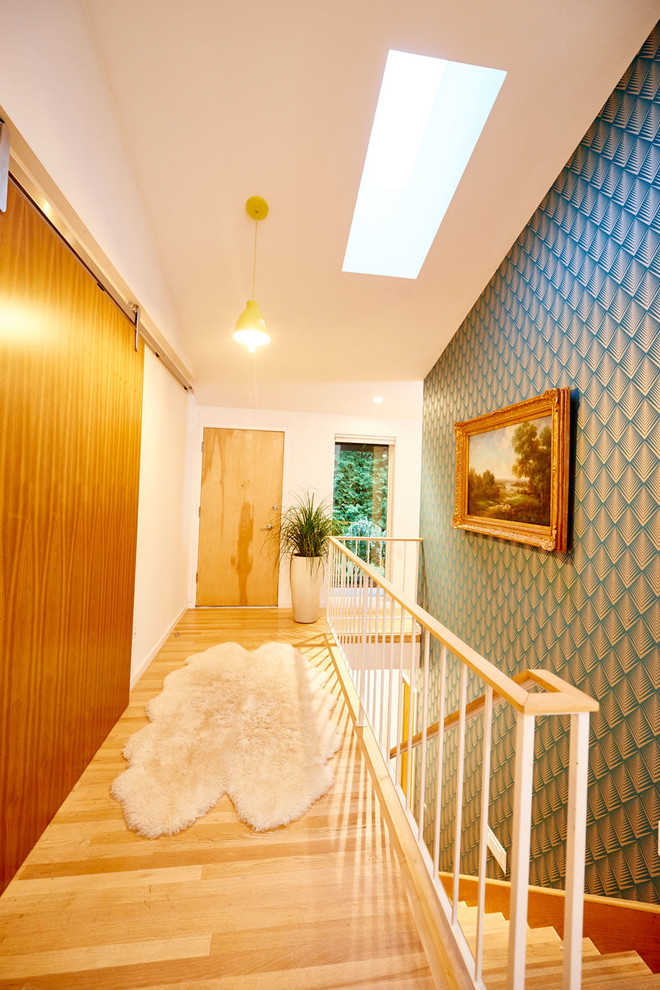 Idee per un grande ingresso o corridoio moderno con pareti bianche, parquet chiaro e pavimento beige