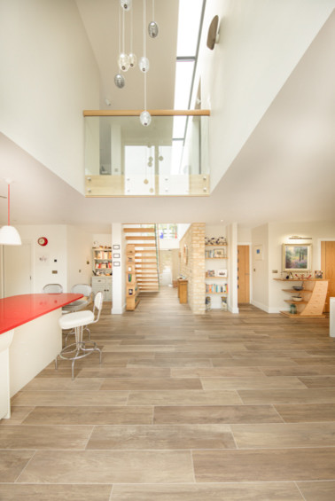 Imagen de recibidores y pasillos minimalistas de tamaño medio con paredes beige, suelo de baldosas de porcelana y suelo marrón