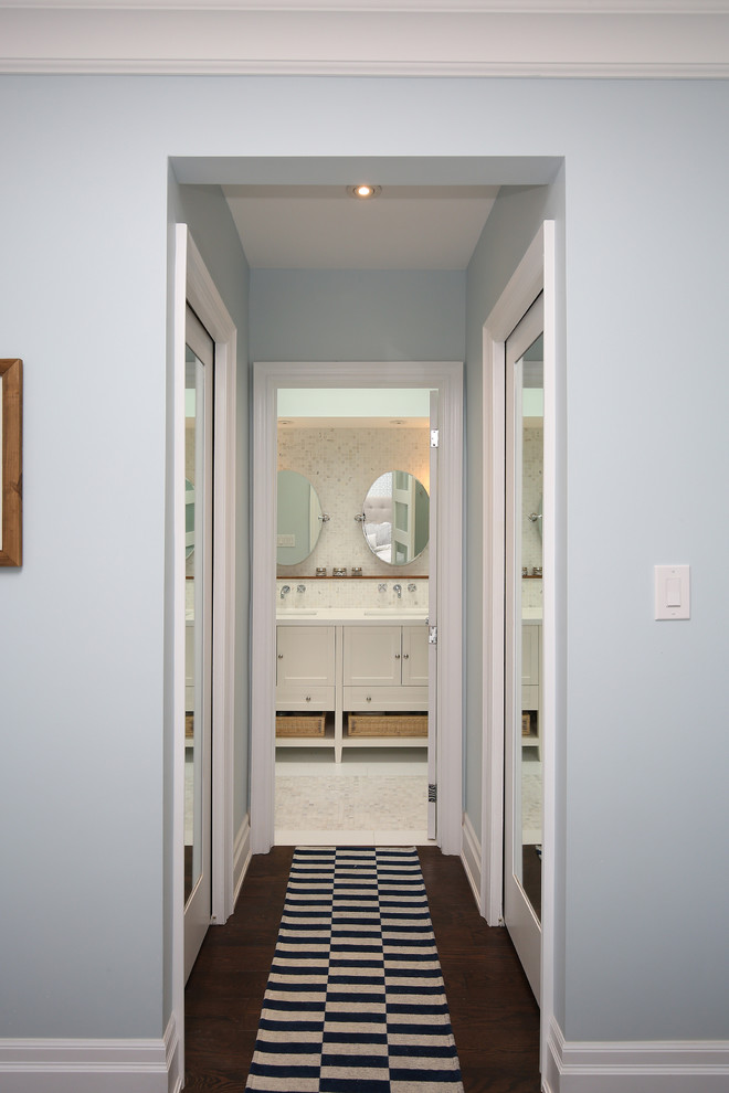 Inspiration pour un petit couloir design avec un mur bleu et un sol en bois brun.