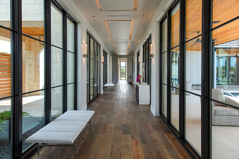 Hallway - large contemporary dark wood floor hallway idea in Dallas with beige walls