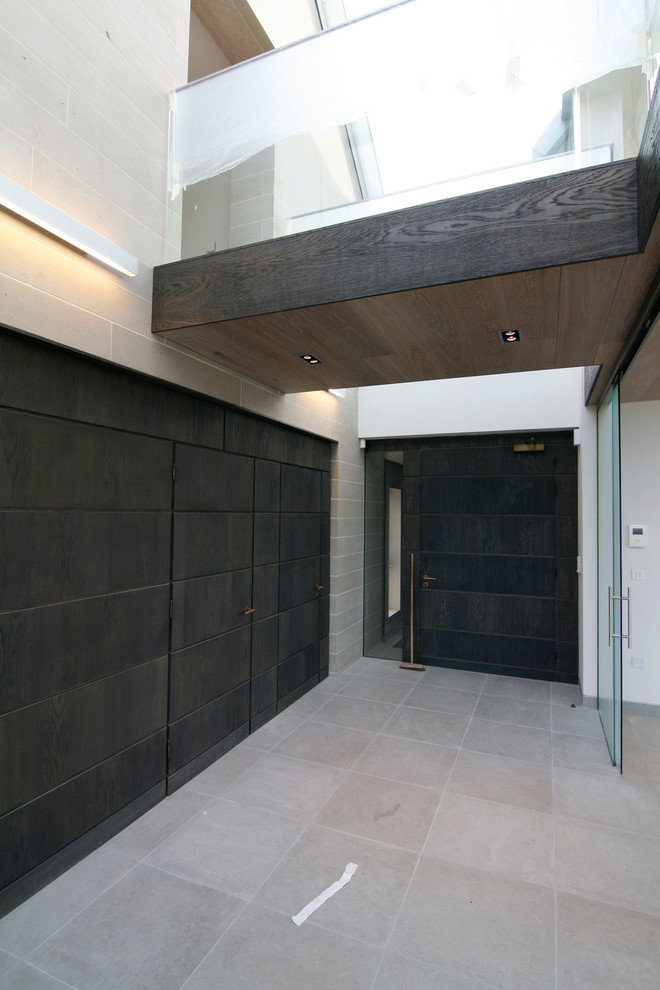 Idée de décoration pour un couloir design avec un mur blanc et un sol gris.