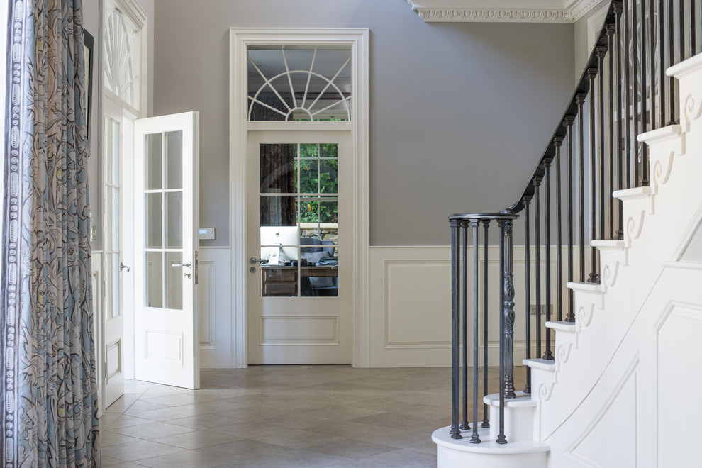 Стильный дизайн: большой коридор в классическом стиле с серыми стенами, полом из терракотовой плитки и серым полом - последний тренд