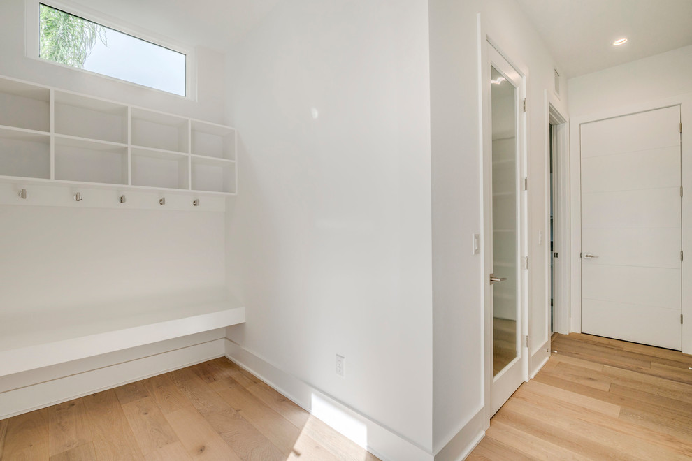 Diseño de recibidores y pasillos minimalistas con paredes blancas y suelo de madera clara