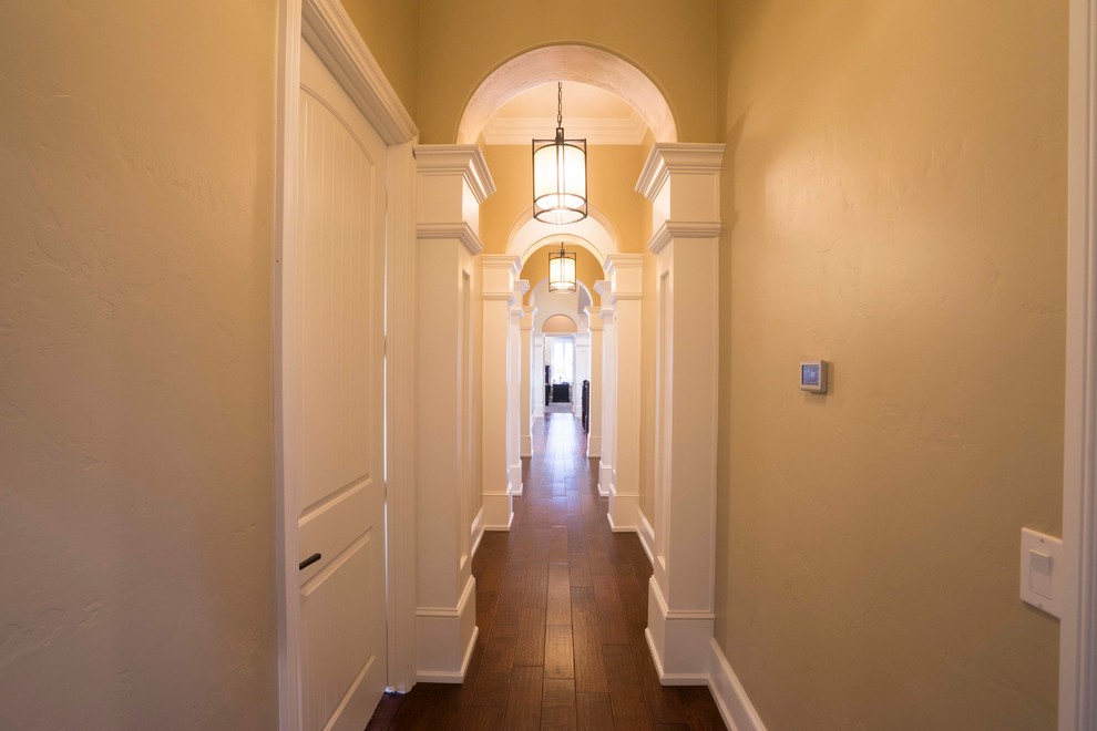 Пример оригинального дизайна: коридор в классическом стиле с бежевыми стенами и темным паркетным полом