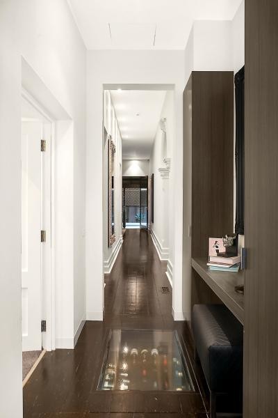 На фото: огромный коридор в стиле модернизм с белыми стенами, темным паркетным полом и коричневым полом с