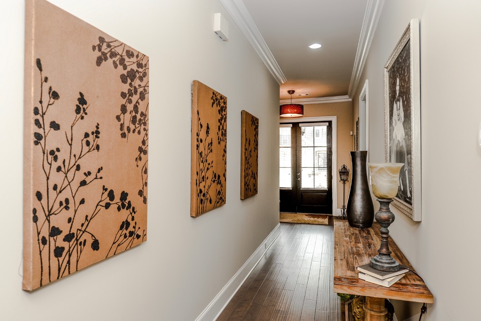 Idée de décoration pour un couloir tradition de taille moyenne avec un mur beige et parquet foncé.