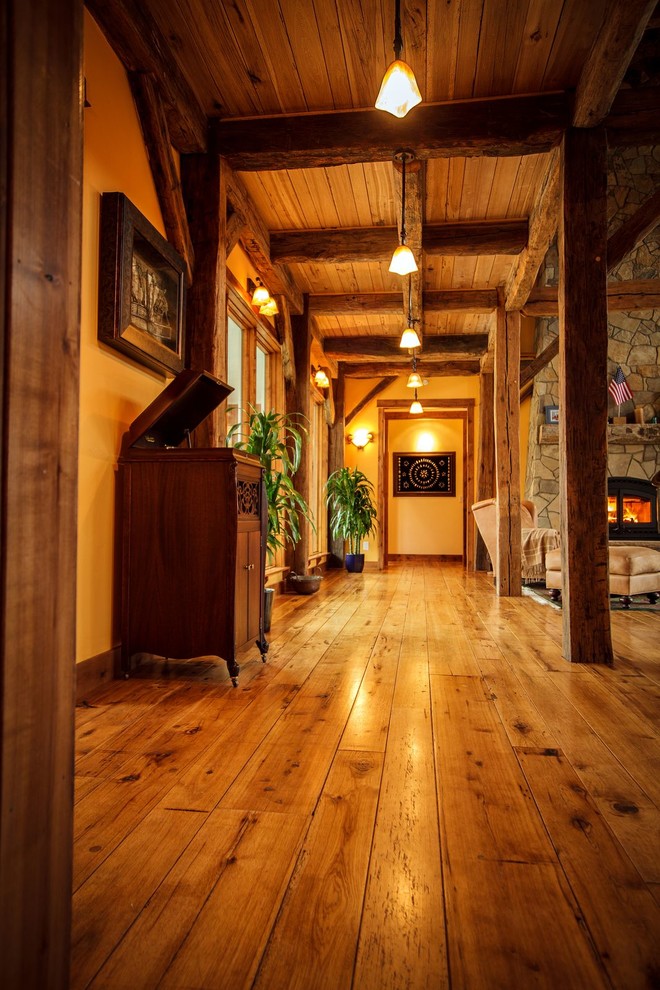 Ispirazione per un grande ingresso o corridoio rustico con pareti beige, pavimento in legno massello medio e pavimento marrone
