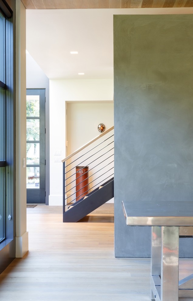 Foto de recibidores y pasillos minimalistas extra grandes con paredes grises, suelo de madera clara y suelo beige