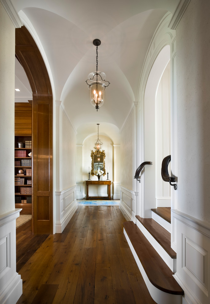 Esempio di un grande ingresso o corridoio classico con pareti bianche, pavimento in legno massello medio e pavimento marrone