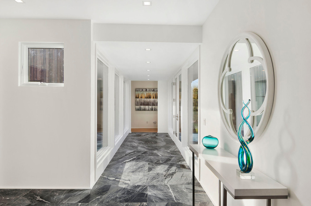 Cette photo montre un couloir tendance de taille moyenne avec un mur blanc, un sol en marbre et un sol noir.