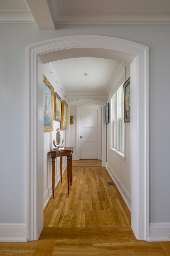 Inspiration pour un couloir traditionnel de taille moyenne avec un mur blanc et parquet clair.